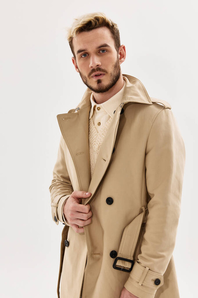 handsome man in coat autumn fashion studio look forward light background - Photo, Image