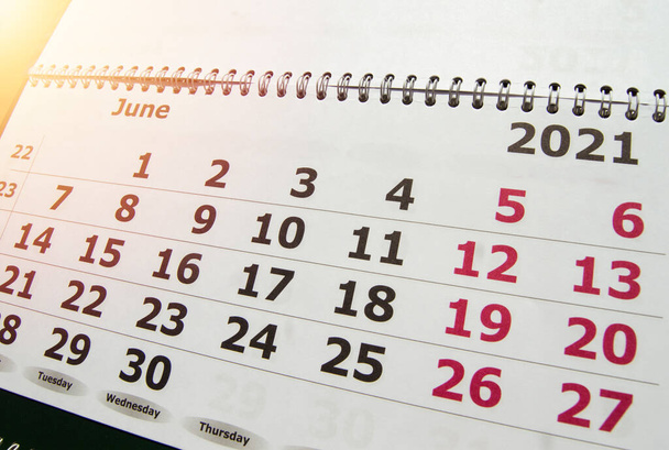 Kalender voor de maand juni 2021, muurkalender met een spiraal op de achtergrond van zonlicht, oplichten. - Foto, afbeelding