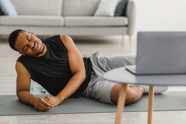 Fáradt fekete srác rosszul érzi magát, miután online edzés otthon - Fotó, kép