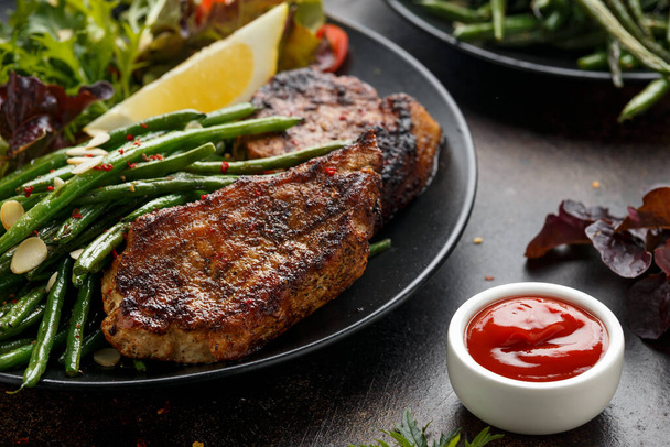 Grilled pork loin chops served with French green beans salad and beer - Photo, Image
