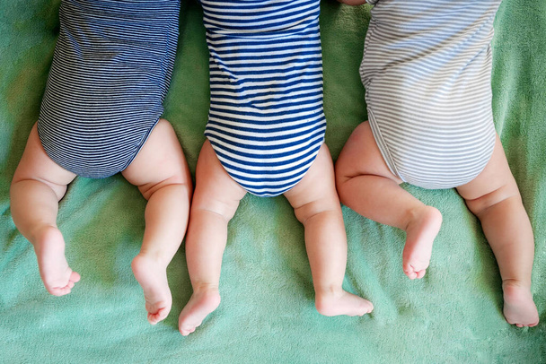 Os rapazes de trigêmeos recém-nascidos estão em um estômago em um cobertor - Foto, Imagem