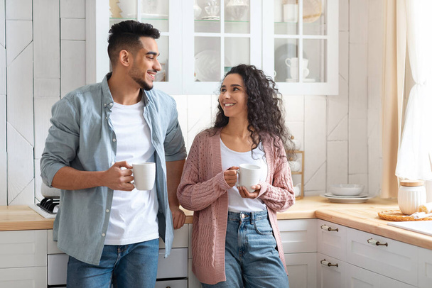 Portrait Of Romantic Young Arab Spouses Drinking Morning Coffee In Kitchen Together - Photo, Image