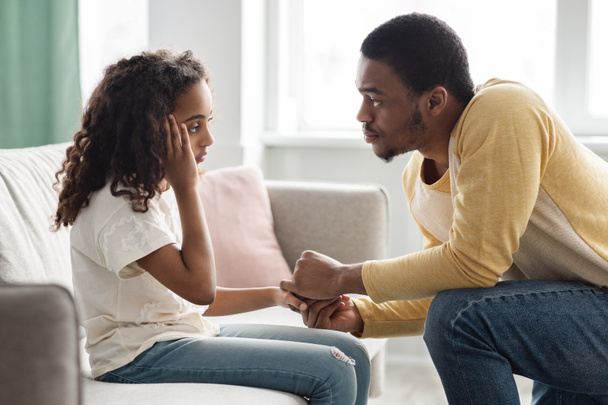 Negro padre reconfortando a su niño molesto, interior del hogar - Foto, Imagen