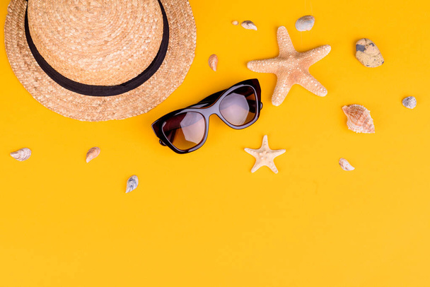 Plážové doplňky: brýle a klobouk s mušlemi a mořskými hvězdami na barevném pozadí. Letní pozadí - Fotografie, Obrázek
