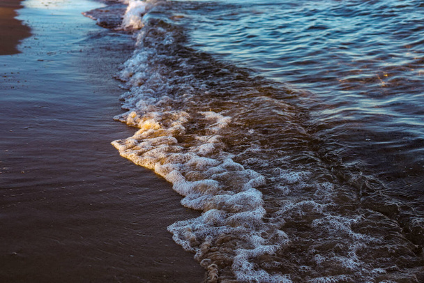 Sea shore. Sand and waves. Beach at sunset. - Foto, Bild
