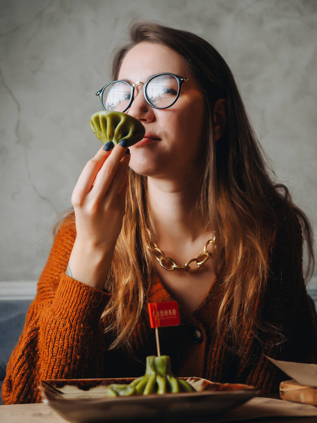 Jeune fille mange vert khinkali dans le restaurant géorgien. - Photo, image