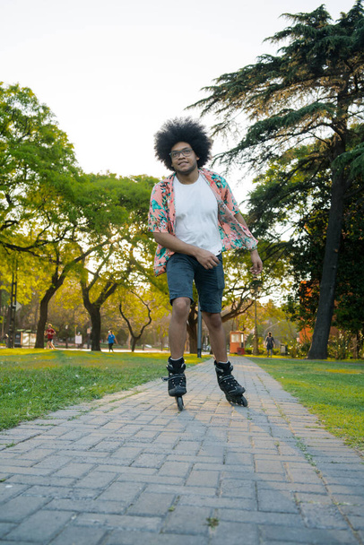Afro Latin man rollerskating outdoors. - 写真・画像