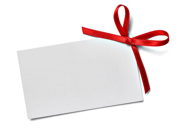 κλείσιμο ευχετήριου σημειώματος κάρτας με κόκκινη κορδέλα σε λευκό φόντο - Φωτογραφία, εικόνα