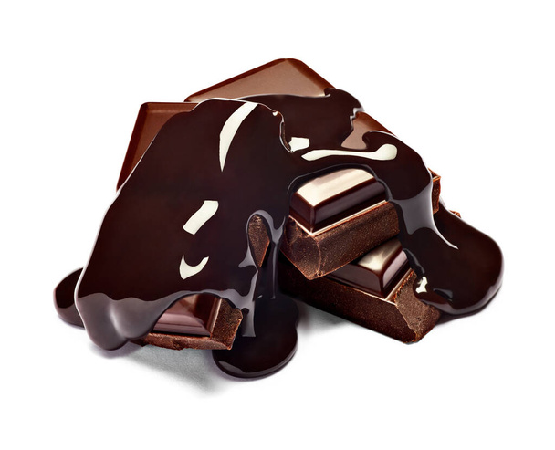 primer plano de pedazos de chocolate pila y jarabe de chocolate sobre fondo blanco - Foto, imagen