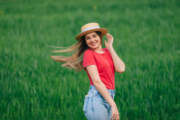 Mujer en sombrero con el pelo largo es feliz, hermosa libre activa en la hierba verde de verano. - Foto, imagen