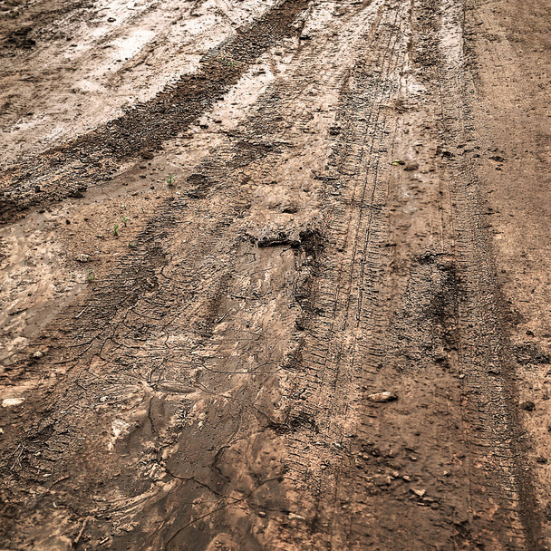Fuera de la carretera. Sucio camino de tierra mojada. Huellas de neumáticos. Rut en un camino fangoso. Huellas de ruedas en la arcilla. Mal tiempo. - Foto, Imagen