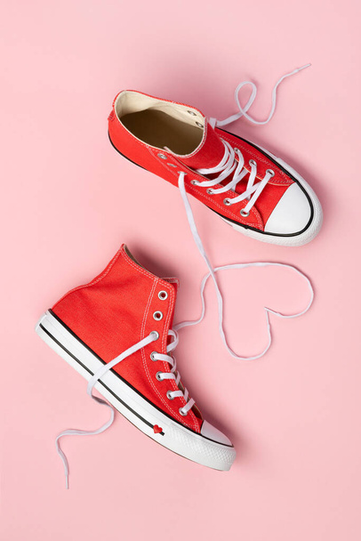 Minimal composition with red sneakers on pink background - Photo, image