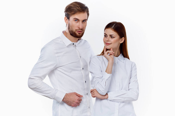 мужчина и женщина в одинаковых рубашках жестикулируют руками на светлом фоне. - Фото, изображение