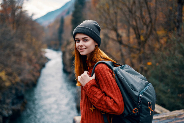 woman with backpack in forest autumn river nature landscape - Foto, imagen