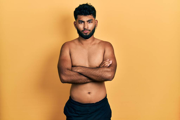 Arab man with beard wearing swimwear shirtless skeptic and nervous, disapproving expression on face with crossed arms. negative person.  - Fotoğraf, Görsel