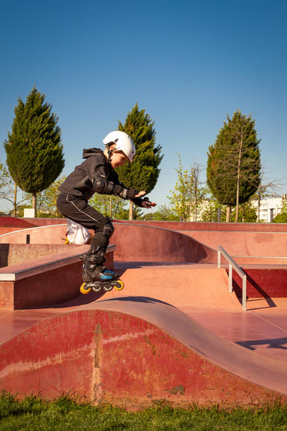 Un garçon patins à roulettes dans un skate park - Photo, image