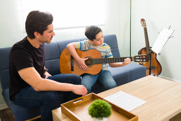 Edistyn kitaratunneillani. Taiteellinen lapsi oppii soittamaan uutta soitinta yksityisen taideopettajan kanssa - Valokuva, kuva