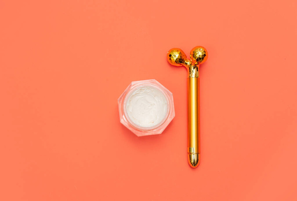 Cream jar and massage gadget on pink background - Photo, Image