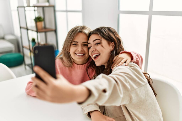 Молода пара посміхається щасливий робить селфі за допомогою смартфона вдома
. - Фото, зображення