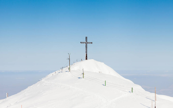アンタースベルク・サミット。オーストリアのウンタースベルク山の頂上からの眺めは、十字架を目指しています。山はドイツとオーストリアの国境をまたいでいる. - 写真・画像