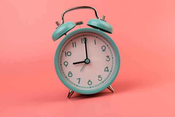 Hermoso reloj despertador azul pastel retro sobre fondo rosa. tiempo para actuar concepto - Foto, imagen