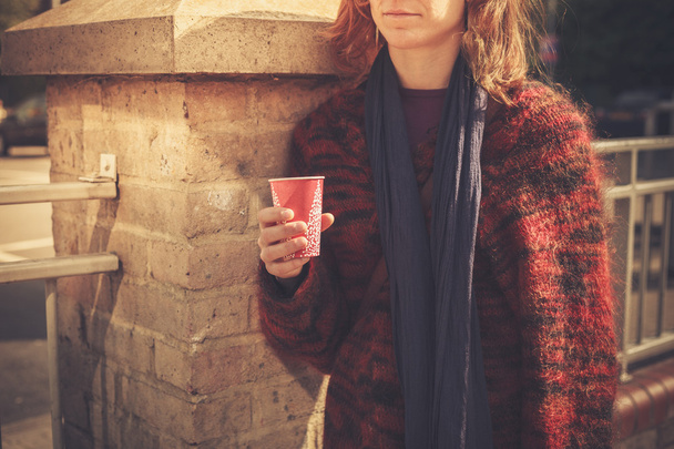 Young woman standing in the street with a paper cup - Foto, immagini