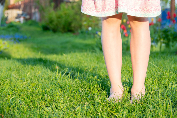 Ноги ребенка на газоне на траве. Селективный фокус. - Фото, изображение