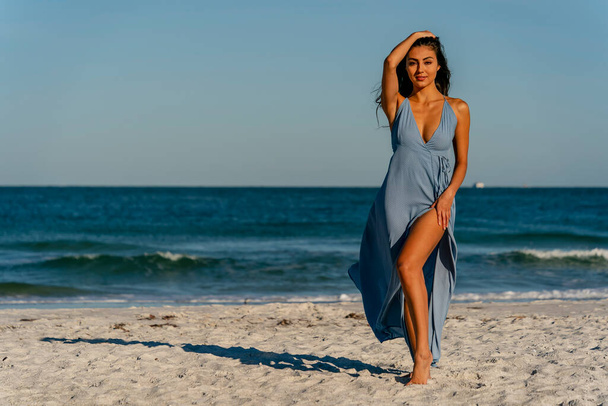 Un hermoso modelo de bikini de raza mixta disfruta del clima al aire libre en la playa - Foto, Imagen