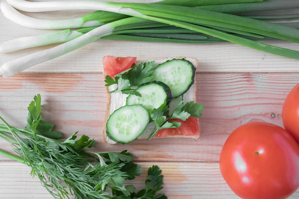 Sandwich with vegetables and herbs, on a wooden background, close-up - Fotografie, Obrázek