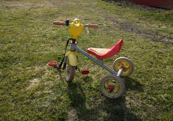 A gyerekek háromkerekű biciklije a mezőn. nyári vakáció koncepció a gyermekek számára. másolás helye. - Fotó, kép