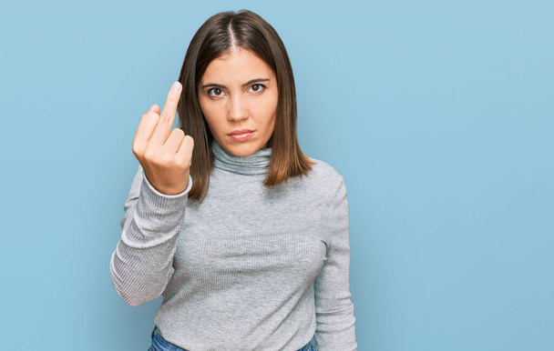 Young beautiful woman wearing casual turtleneck sweater showing middle finger, impolite and rude fuck off expression  - Fotoğraf, Görsel
