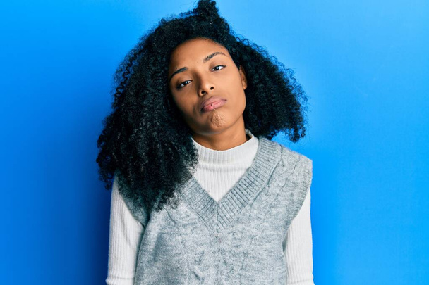 African american woman with afro hair wearing casual winter sweater looking sleepy and tired, exhausted for fatigue and hangover, lazy eyes in the morning.  - Photo, Image