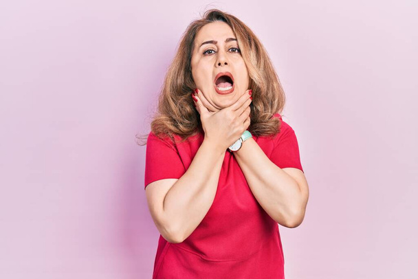 Middle age caucasian woman wearing casual clothes shouting suffocate because painful strangle. health problem. asphyxiate and suicide concept.  - Fotoğraf, Görsel