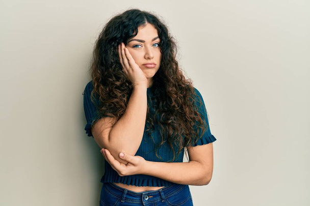 Young brunette woman with curly hair wearing casual clothes thinking looking tired and bored with depression problems with crossed arms.  - Photo, Image