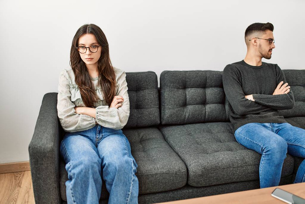 Jovem casal hispânico irritado sentado no sofá em silêncio em casa. - Foto, Imagem