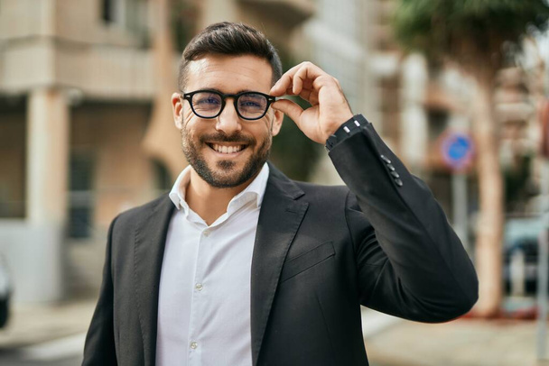 Молодий іспаномовний бізнесмен усміхнений щасливий стоячи в місті
. - Фото, зображення