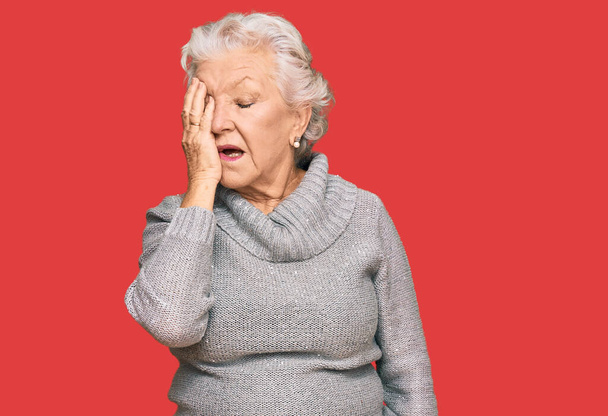 Senior harmaa tukka nainen yllään rento talvi villapaita haukottelu väsynyt kattaa puoli kasvot, silmä ja suu käsin. kasvojen kipu kipu.  - Valokuva, kuva