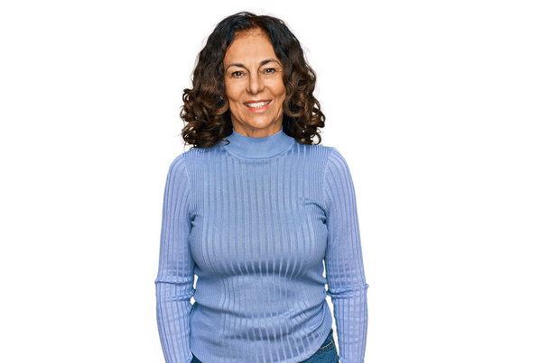 Mujer hispana de mediana edad vistiendo ropa casual luciendo positiva y feliz de pie y sonriendo con una sonrisa confiada mostrando los dientes  - Foto, Imagen
