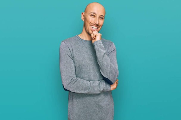 Bald man with beard wearing casual clothes looking confident at the camera with smile with crossed arms and hand raised on chin. thinking positive.  - Photo, Image