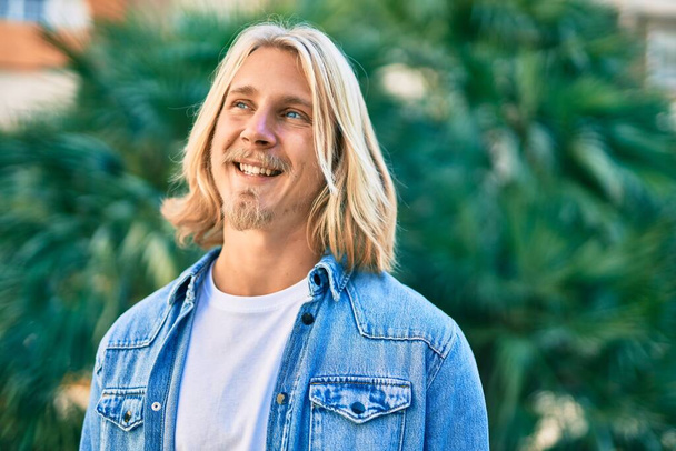 Young blond scandinavian man smiling happy standing at the city. - Photo, Image