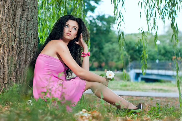 Beautiful Young Women lie on a grass with rose - Foto, afbeelding