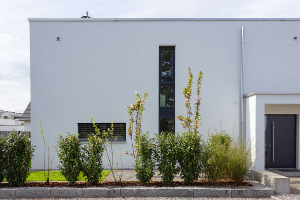 σύγχρονος κήπος των σπιτιών την άνοιξη στη Γερμανία με φρέσκα φυτά πράσινο και πέτρινες προσόψεις τοίχων - Φωτογραφία, εικόνα