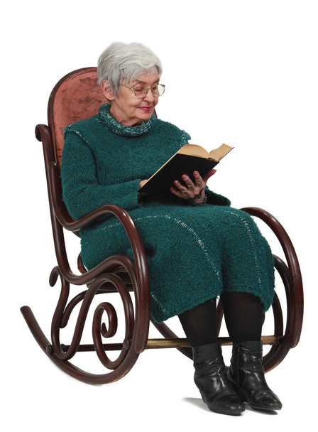 Old woman reading a black book while sitting in a rocker, isolated against a white background. - Foto, Imagem
