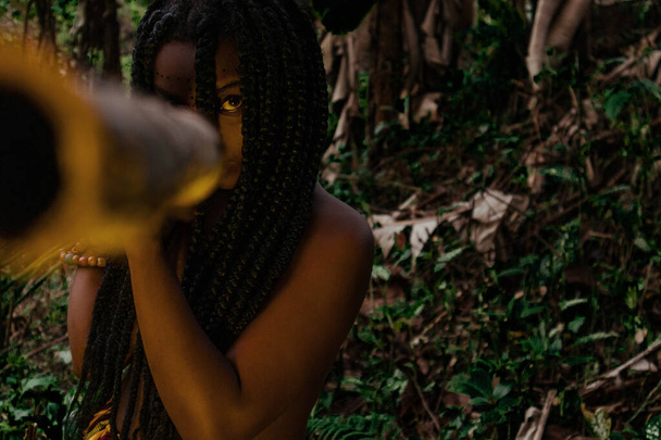 Mujer negra de selva apunta con arma amenazante - Foto, Bild