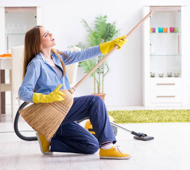 Junge Frau putzt Fußboden zu Hause und erledigt Hausarbeiten - Foto, Bild