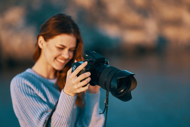 Nainen, jolla on kamera, jossa on linssi luonnossa vuorilla ja meressä  - Valokuva, kuva
