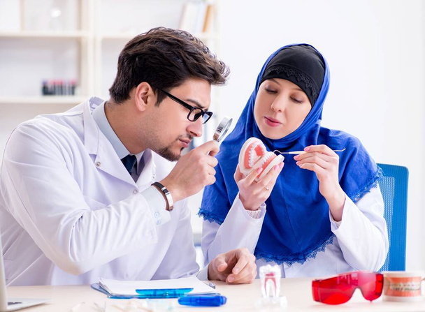 Médecin dentiste et assistant travaillant sur un nouvel implant dentaire - Photo, image