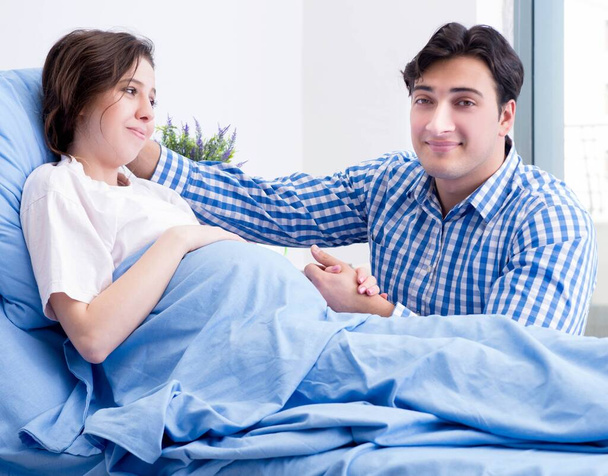 zorgzame liefhebbende echtgenoot bezoeken zwangere vrouw in ziekenhuis - Foto, afbeelding