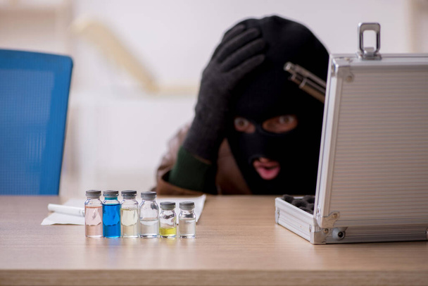 Kar maskeli genç adam laboratuvardan aşı çalıyor. - Fotoğraf, Görsel