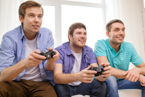smiling friends playing video games at home - Valokuva, kuva